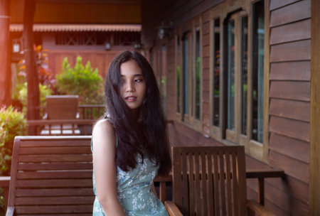 young indonesian woman stay at wooden home resort,
young woman at balconyの写真素材