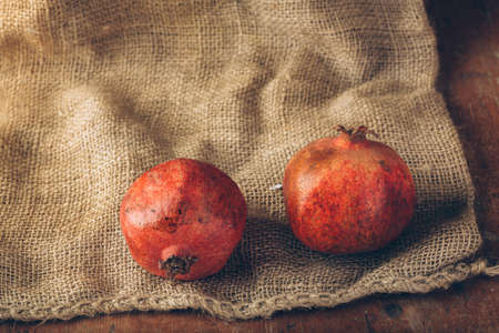 Styled shot of pomegranate on burlap backgroundの写真素材