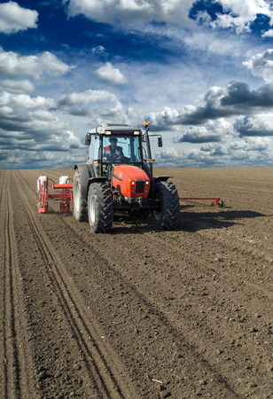 Farmer in tractor sowing corn maize cropsの写真素材