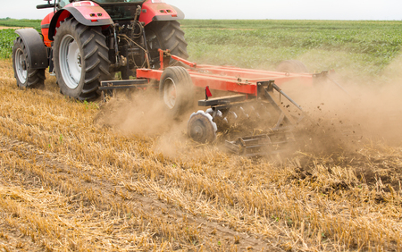 Tractor cultivating wheat stubble field, crop residue.の写真素材