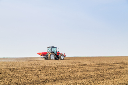 Farmer fertilizing arable land with nitrogen, phosphorus, potassium fertilizerの写真素材