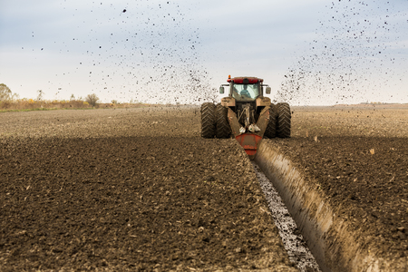 Tractor with double wheeled ditcher digging drainage canalの写真素材