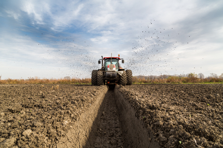 Tractor with double wheeled ditcher digging drainage canalの写真素材