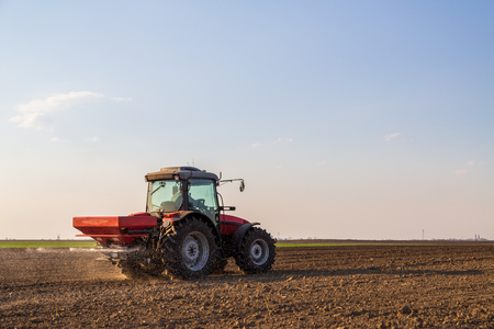 Farmer fertilizing arable land with nitrogen, phosphorus, potassium fertilizerの写真素材