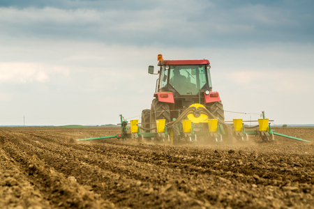 Farmer seeding, sowing crops at field. Sowing is the process of planting seeds in the ground as part of the early spring time agricultural activities.の写真素材