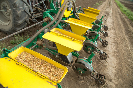 Farmer seeding, sowing crops at field. Sowing is the process of planting seeds in the ground as part of the early spring time agricultural activities.の写真素材