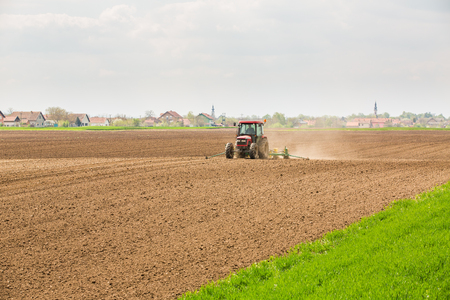 Farmer seeding, sowing crops at field. Sowing is the process of planting seeds in the ground as part of the early spring time agricultural activities.の写真素材