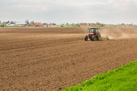 Farmer seeding, sowing crops at field. Sowing is the process of planting seeds in the ground as part of the early spring time agricultural activities.の写真素材