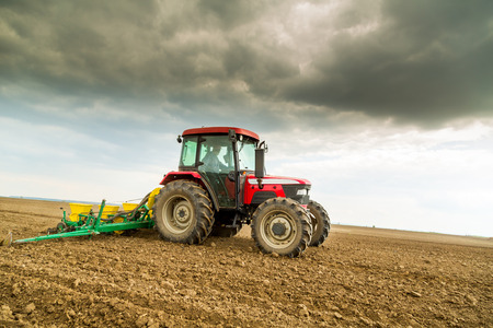 Farmer seeding, sowing crops at field. Sowing is the process of planting seeds in the ground as part of the early spring time agricultural activities.の写真素材