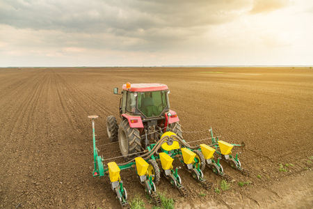 Farmer seeding, sowing crops at field. Sowing is the process of planting seeds in the ground as part of the early spring time agricultural activities.の写真素材