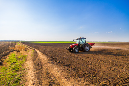 Farmer fertilizing arable land with nitrogen, phosphorus, potassium fertilizerの写真素材