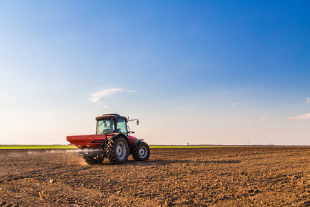 Farmer fertilizing arable land with nitrogen, phosphorus, potassium fertilizerの写真素材