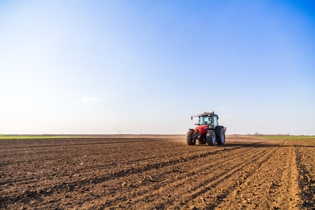 Farmer fertilizing arable land with nitrogen, phosphorus, potassium fertilizerの写真素材