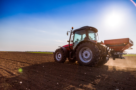 Farmer fertilizing arable land with nitrogen, phosphorus, potassium fertilizerの写真素材