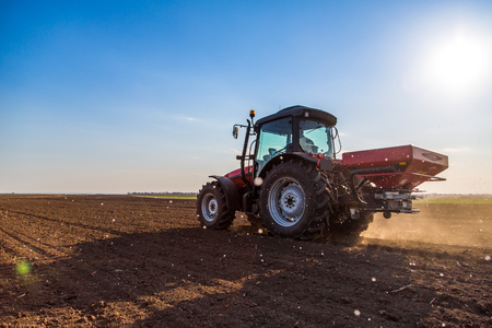 Farmer fertilizing arable land with nitrogen, phosphorus, potassium fertilizerの写真素材