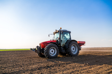 Farmer fertilizing arable land with nitrogen, phosphorus, potassium fertilizerの写真素材