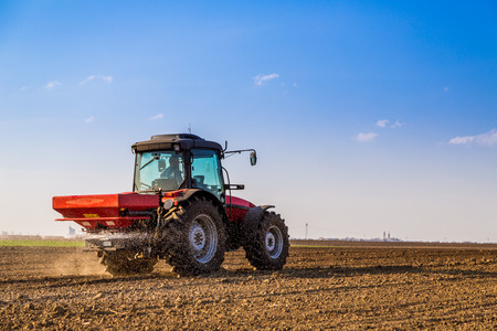 Farmer fertilizing arable land with nitrogen, phosphorus, potassium fertilizerの写真素材