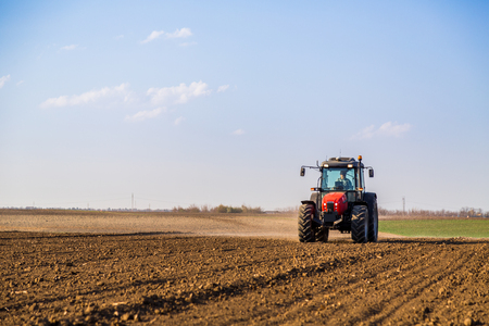 Farmer fertilizing arable land with nitrogen, phosphorus, potassium fertilizerの写真素材