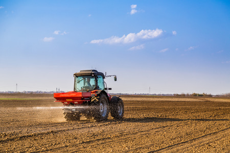 Farmer fertilizing arable land with nitrogen, phosphorus, potassium fertilizerの写真素材