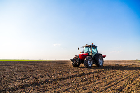 Farmer fertilizing arable land with nitrogen, phosphorus, potassium fertilizerの写真素材