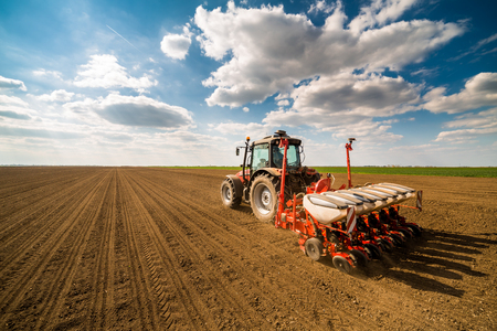 Farmer seeding, sowing crops at field. Sowing is the process of planting seeds in the ground as part of the early spring time agricultural activities.の写真素材