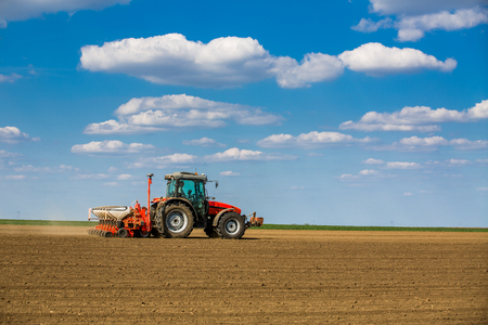 Farmer seeding, sowing crops at field. Sowing is the process of planting seeds in the ground as part of the early spring time agricultural activities.の写真素材