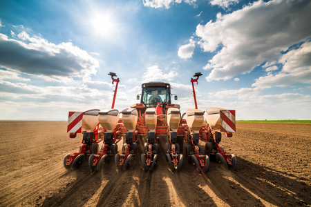 Farmer seeding, sowing crops at field. Sowing is the process of planting seeds in the ground as part of the early spring time agricultural activities.の写真素材