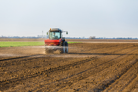 Farmer fertilizing arable land with nitrogen, phosphorus, potassium fertilizerの写真素材