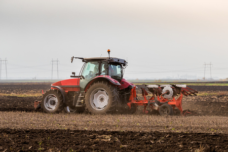 Farmer plowing stubble fieldの写真素材