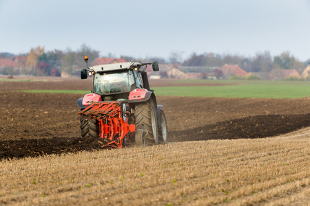 Farmer plowing stubble fieldの写真素材