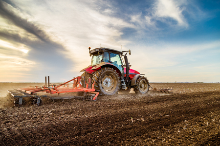 Tractor cultivating field at springの写真素材