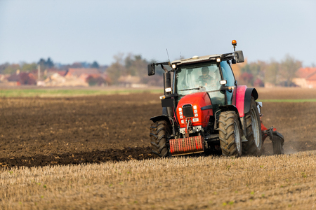 Farmer plowing stubble fieldの写真素材