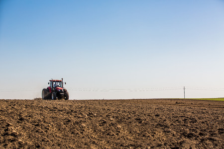 Tractor cultivating field at springの写真素材