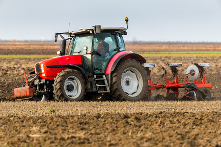 Farmer plowing stubble fieldの写真素材