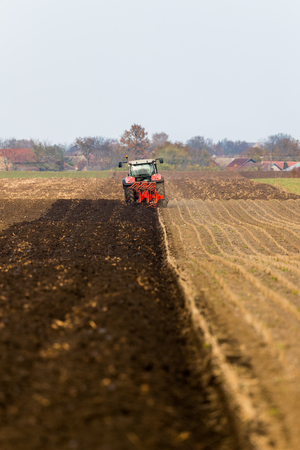 Farmer plowing stubble fieldの写真素材