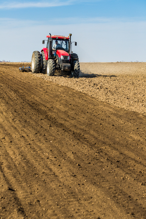 Tractor cultivating field at springの写真素材
