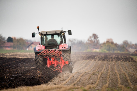 Farmer plowing stubble fieldの写真素材