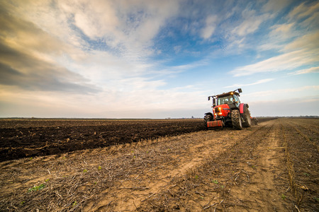 Farmer plowing stubble fieldの写真素材