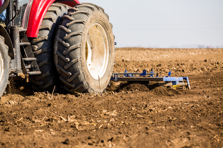 Tractor cultivating field at springの写真素材