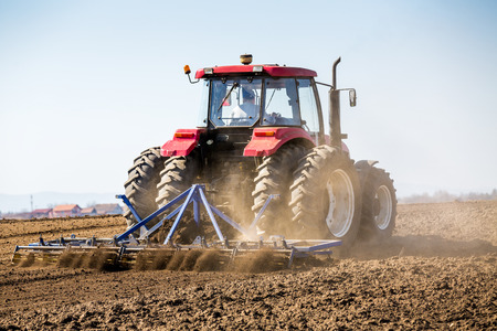 Tractor cultivating field at springの写真素材