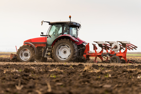 Farmer plowing stubble fieldの写真素材