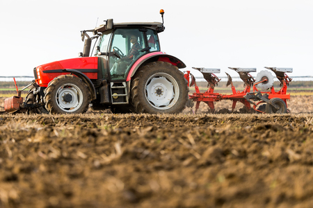 Farmer plowing stubble fieldの写真素材