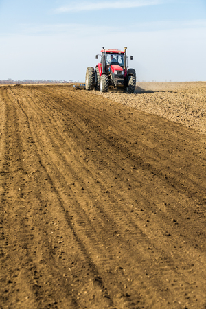 Tractor cultivating field at springの写真素材