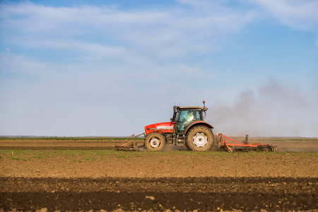 Tractor cultivating field at springの写真素材
