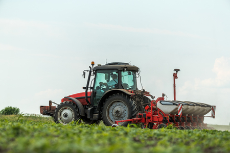 Farmer seeding, sowing crops at field. Sowing is the process of planting seeds in the ground as part of the early spring time agricultural activities.の写真素材
