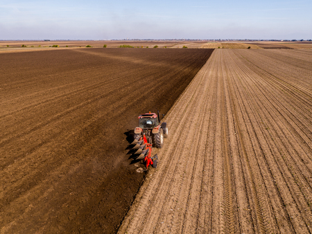 Aerial shot of a farmer plowing stubble fieldの写真素材