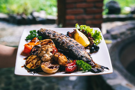 The fish dish is grilled with vegetables, potatoes and spices.