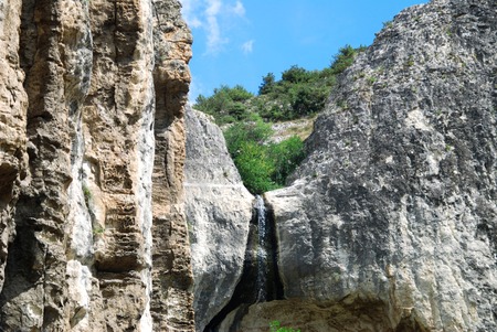 Waterfall in a mountain on a background of blue skyの写真素材