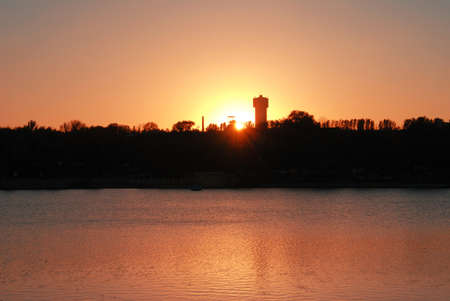 Sunset in the city. Against the background of the river, the sky and the industrial cityの写真素材