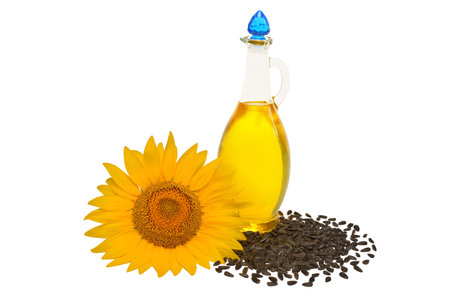 Creative idea flower of a sunflower, seeds and oil glass bottle isolated on white background. Food, cooking, farm work. Agriculture, organic. Flat lay, top viewの写真素材